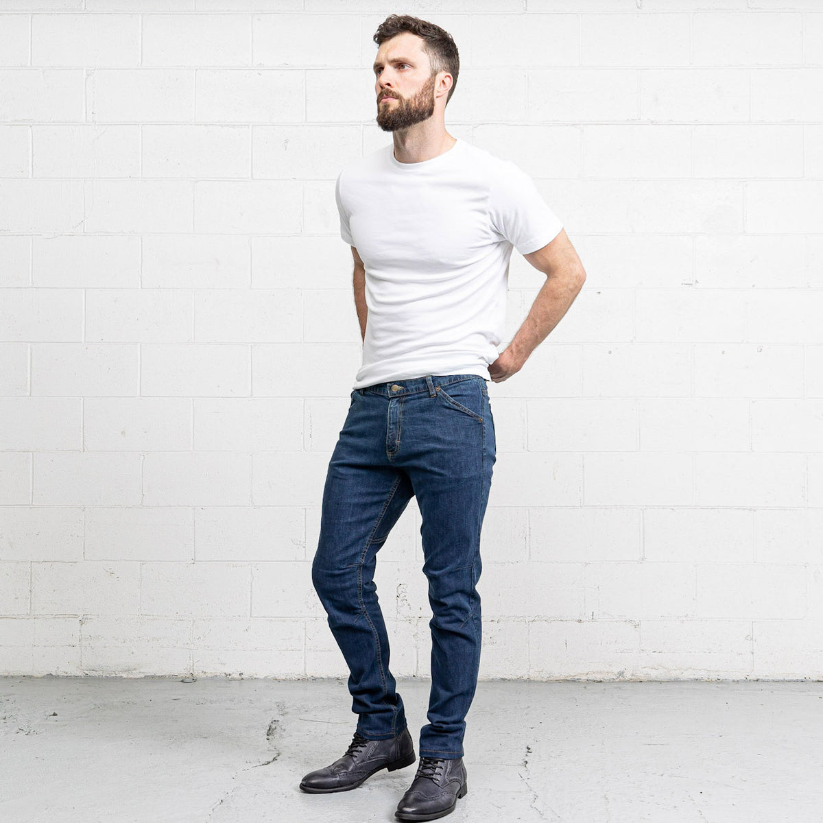 Side view of Commuter medium wash jeans showing hip and slim leg below the knee.