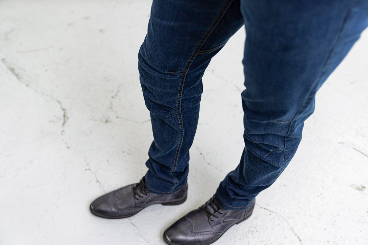 Cuff and hem detail of Commuter medium wash jeans over shoes.