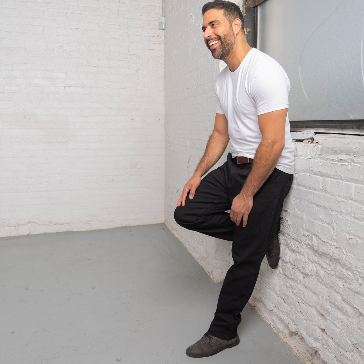Back view of black relaxed fit jeans showing back pockets and Horween leather patch at the waistband.