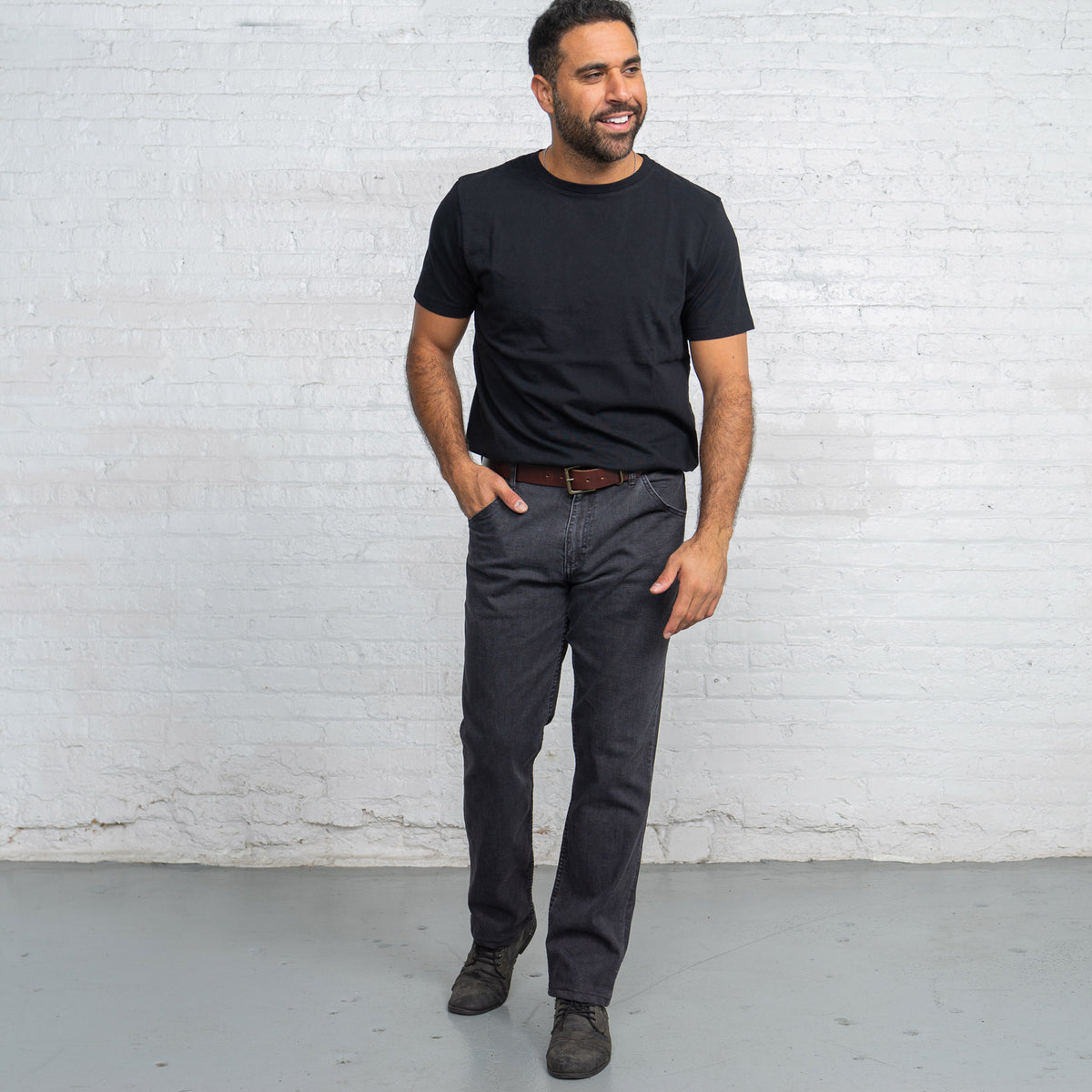 Back view of grey wash relaxed fit jeans showing back pockets and Horween leather patch