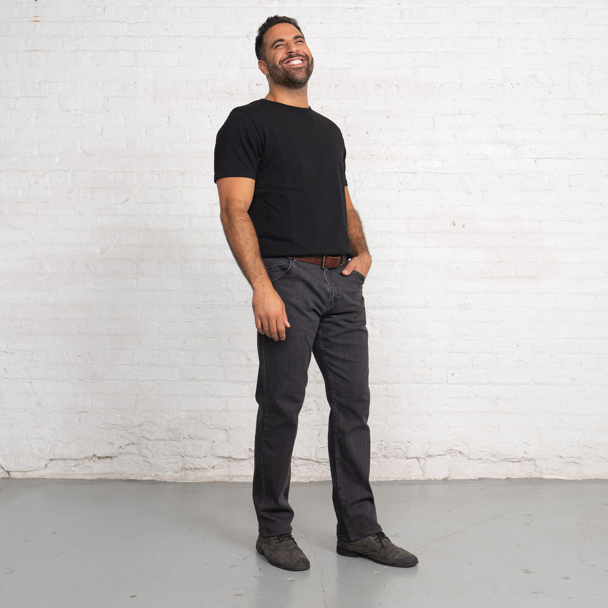 Relaxed fit grey jeans worn with cuffed hem, side view of leg and pocket