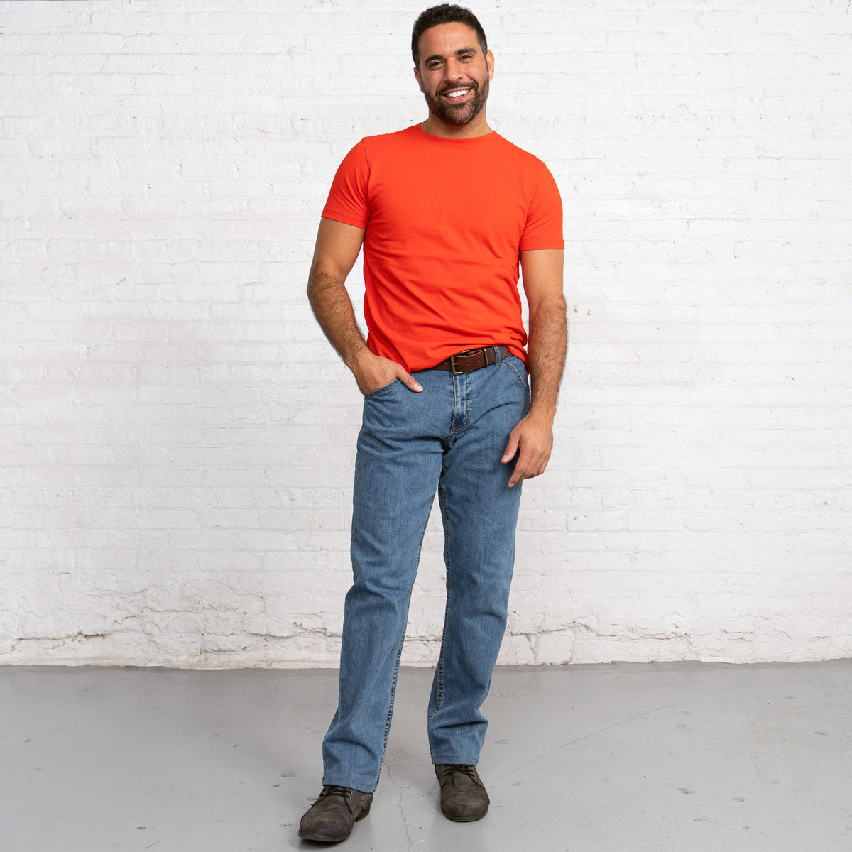 Back view of light wash relaxed fit jeans showing back pockets and leather patch.
