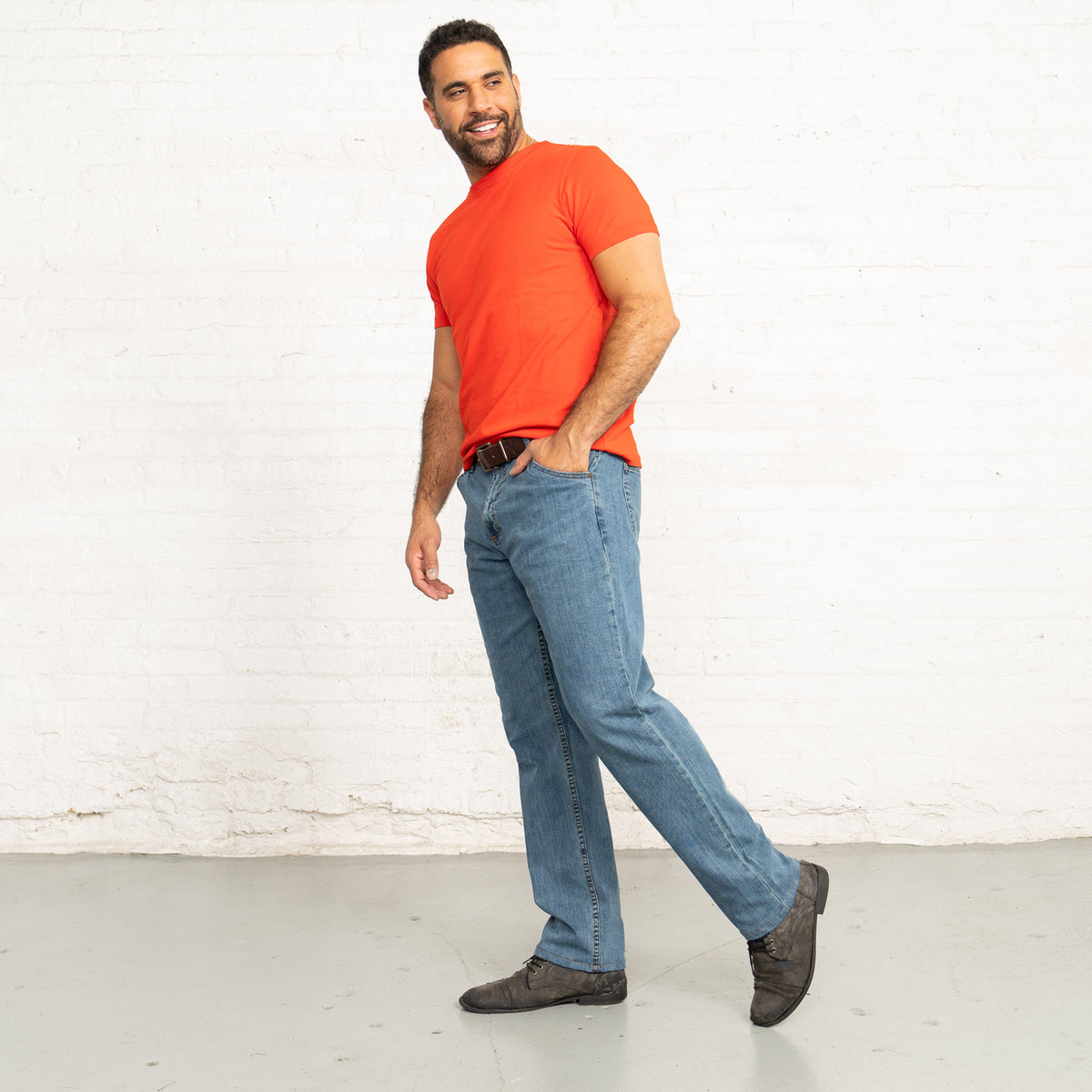 Close-up of front pocket, zipper fly and waistband on light wash jeans.