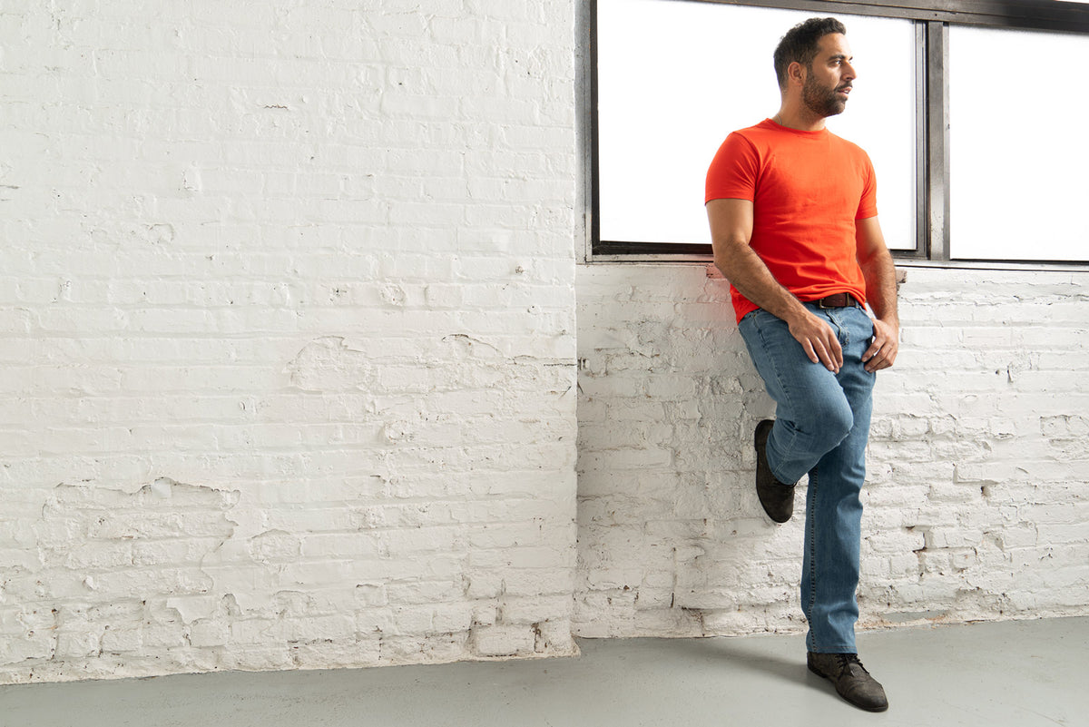 Hem and 16 inch leg opening of light wash relaxed fit jeans over shoes.