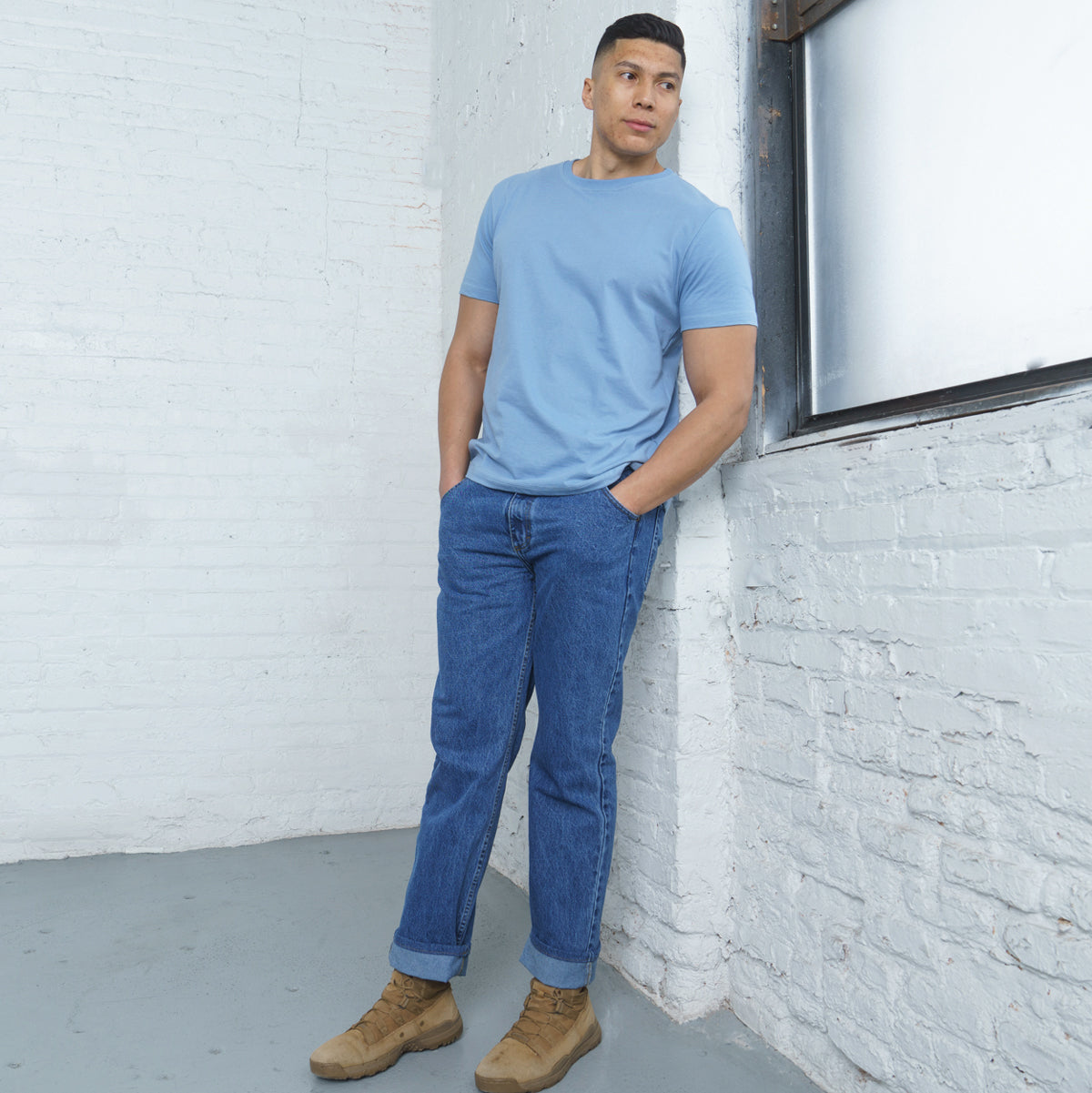 Man wearing relaxed fit stone wash jeans, full-length side view