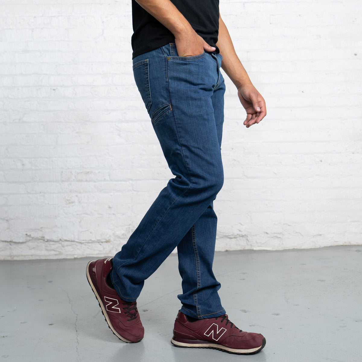 Side view of the tapered leg on medium wash stretch jeans