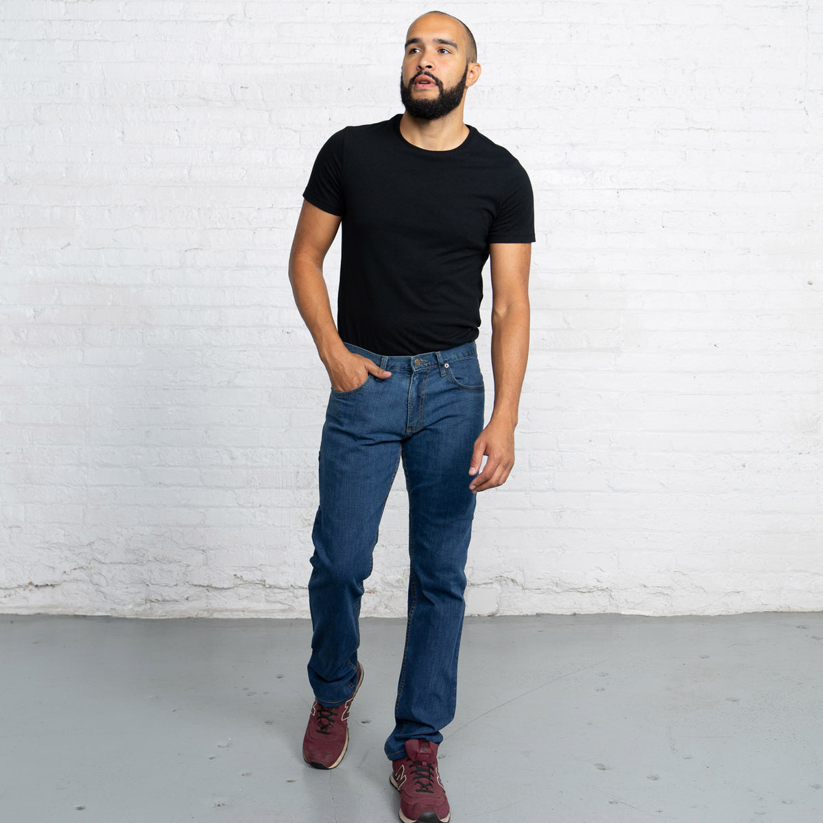 Back view of medium wash Tailored Fit jeans showing back pockets and Horween leather patch