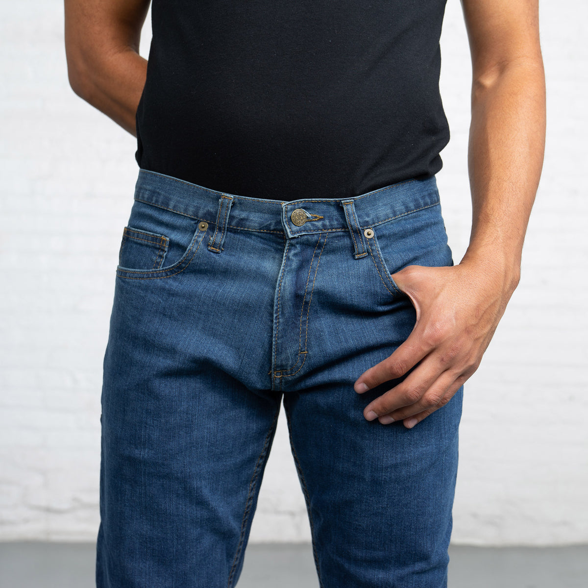 Detail of the gold leaf button and YKK zipper fly on medium wash denim