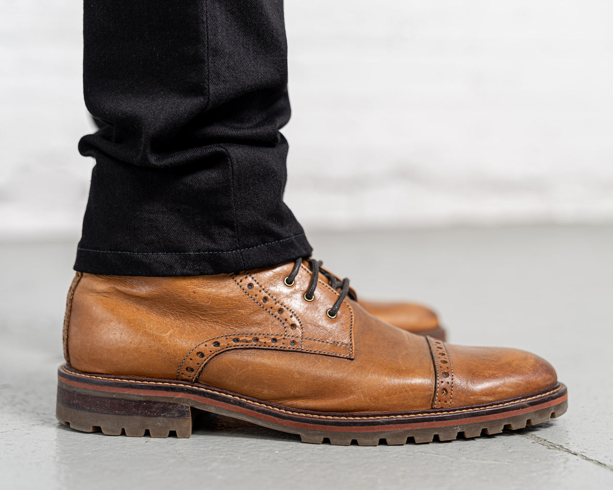 Man wearing black Tailored Fit jeans, side view showing taper below the knee