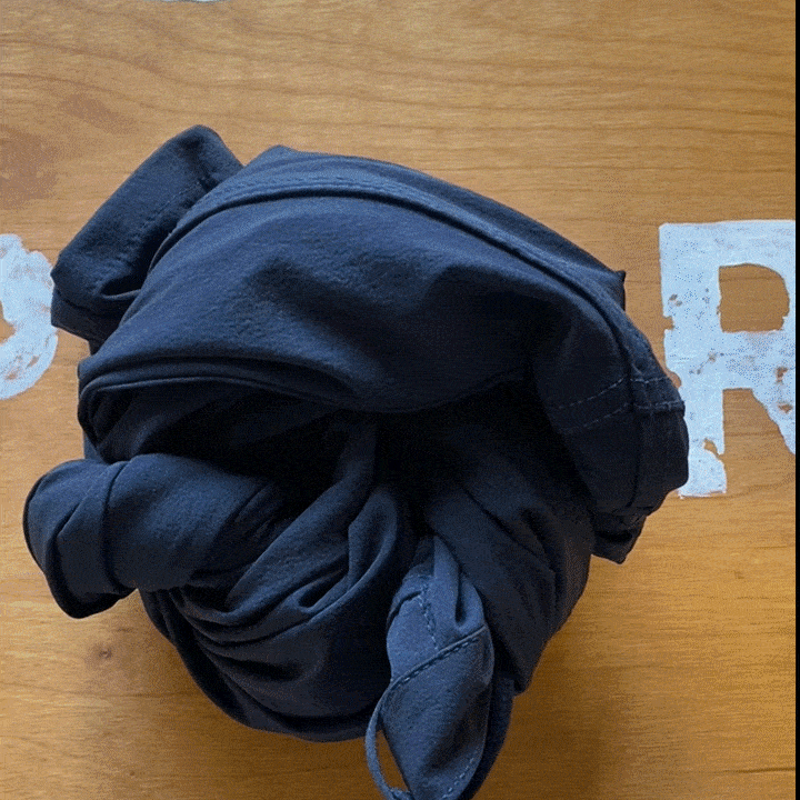 Detail of the front waistband, button and YKK zipper fly on navy technical jeans.