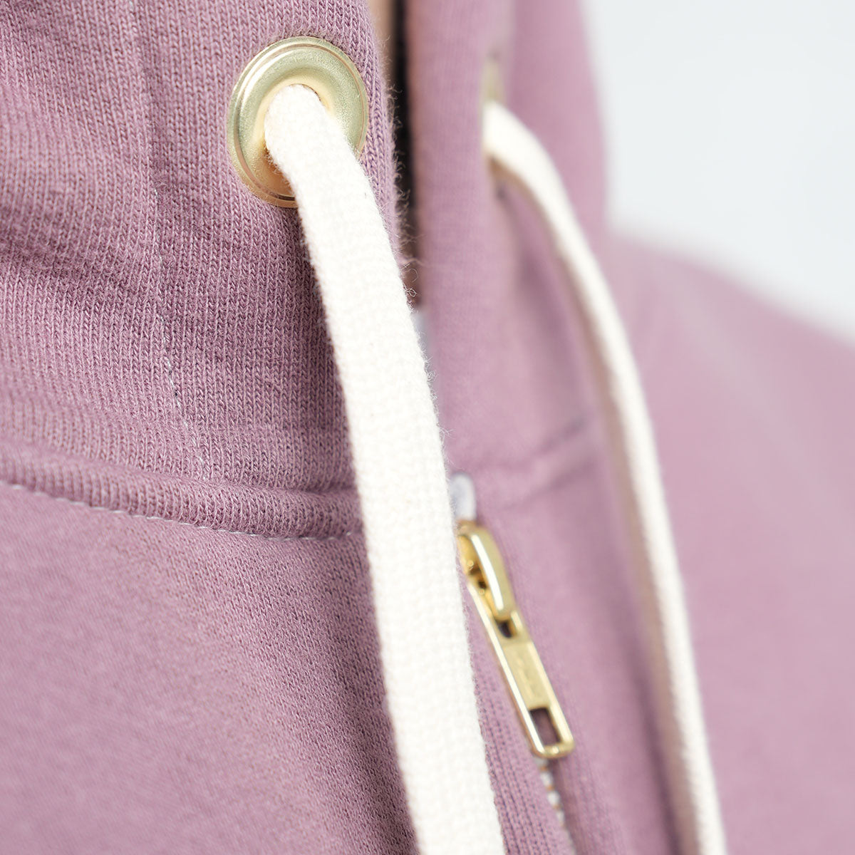 Close-up of the YKK zipper pull on the rose taupe zip-up hoodie