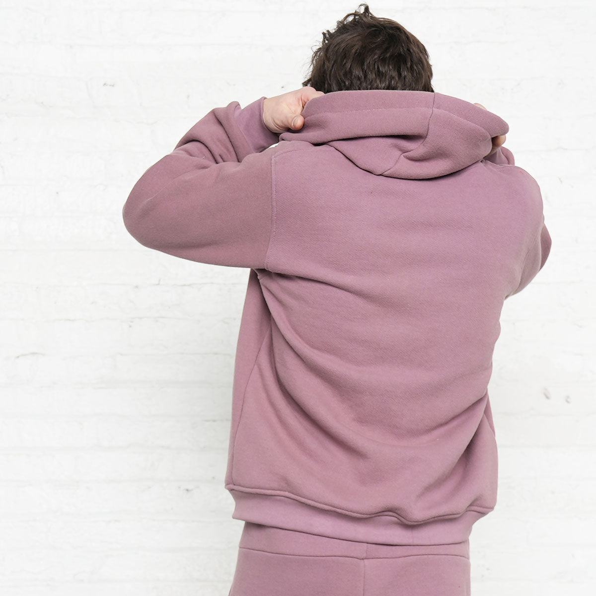 Rose taupe hoodie worn open over a tee, showing the YKK zipper and front pockets